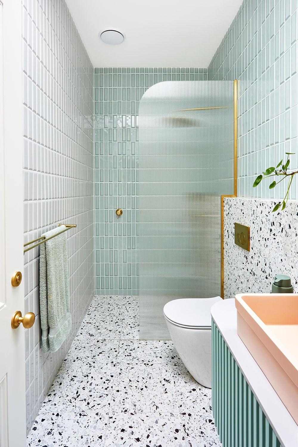 Baño moderno con azulejos verticales color verde menta