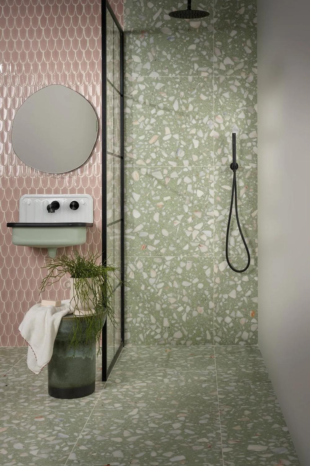 Modern bathroom showcasing green terrazzo flooring and stylish retro-inspired sink.