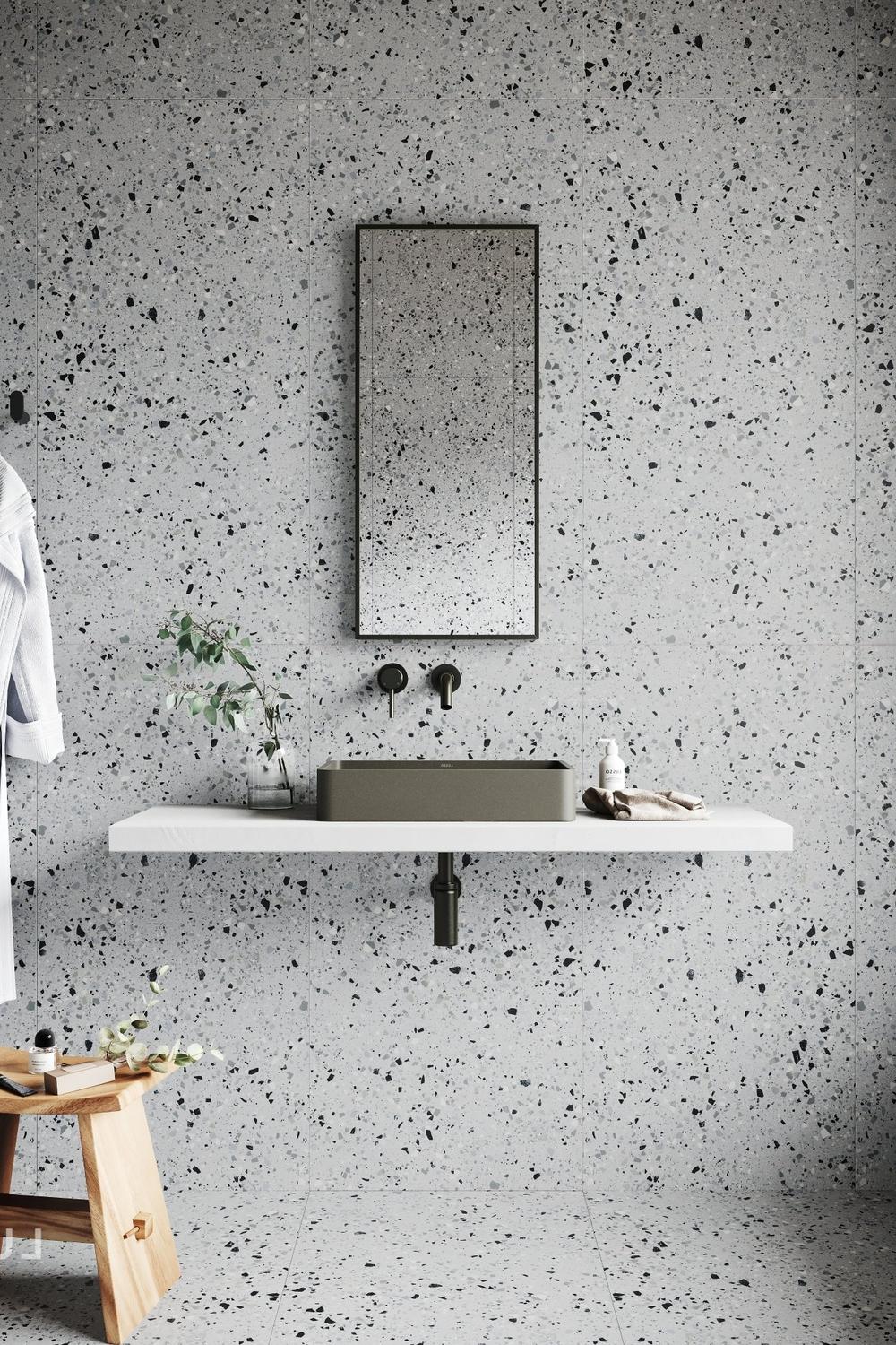 Calm modern bathroom with light gray terrazzo and soft natural light.