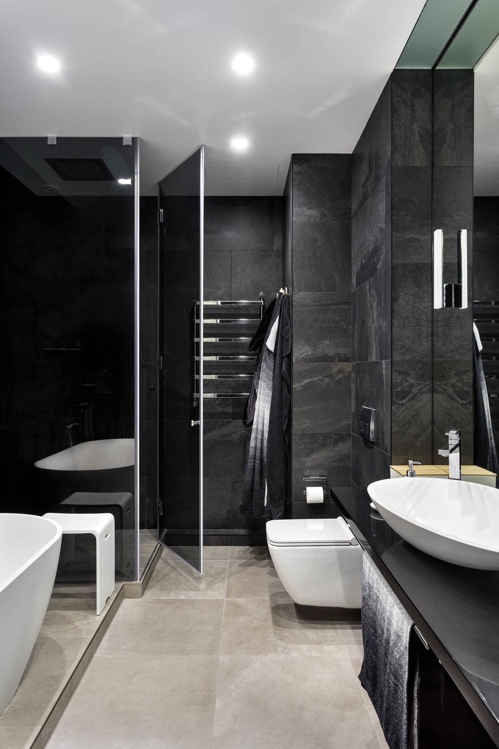 Baño minimalista con azulejos oscuros y bañera de estilo contemporáneo