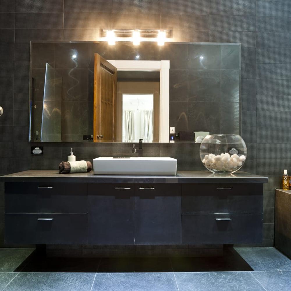 Baño de diseño minimalista con azulejos oscuros y mármol