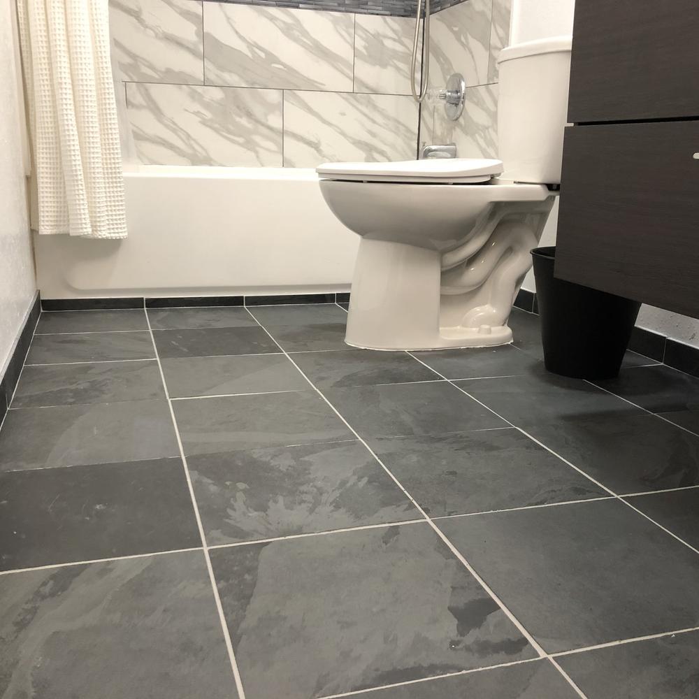 Bathroom featuring a mix of dusk slate floor and light marble wall.
