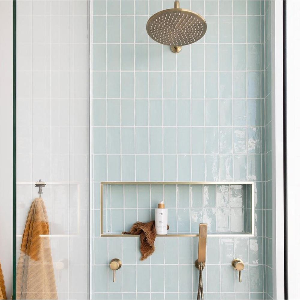 Azulejos en tonos verde menta con detalles en bronce