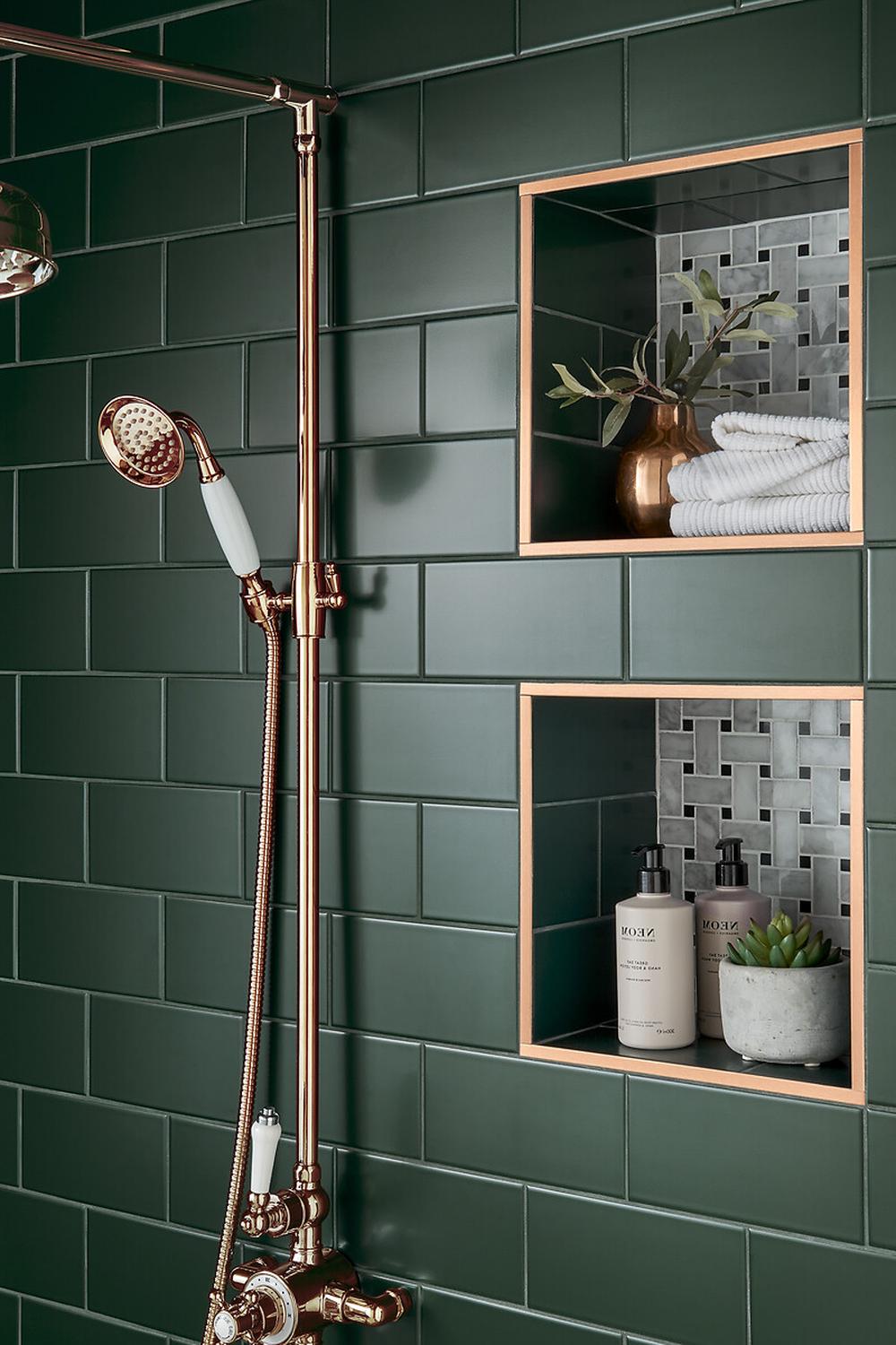 Ducha con azulejos verde oliva y detalles dorados