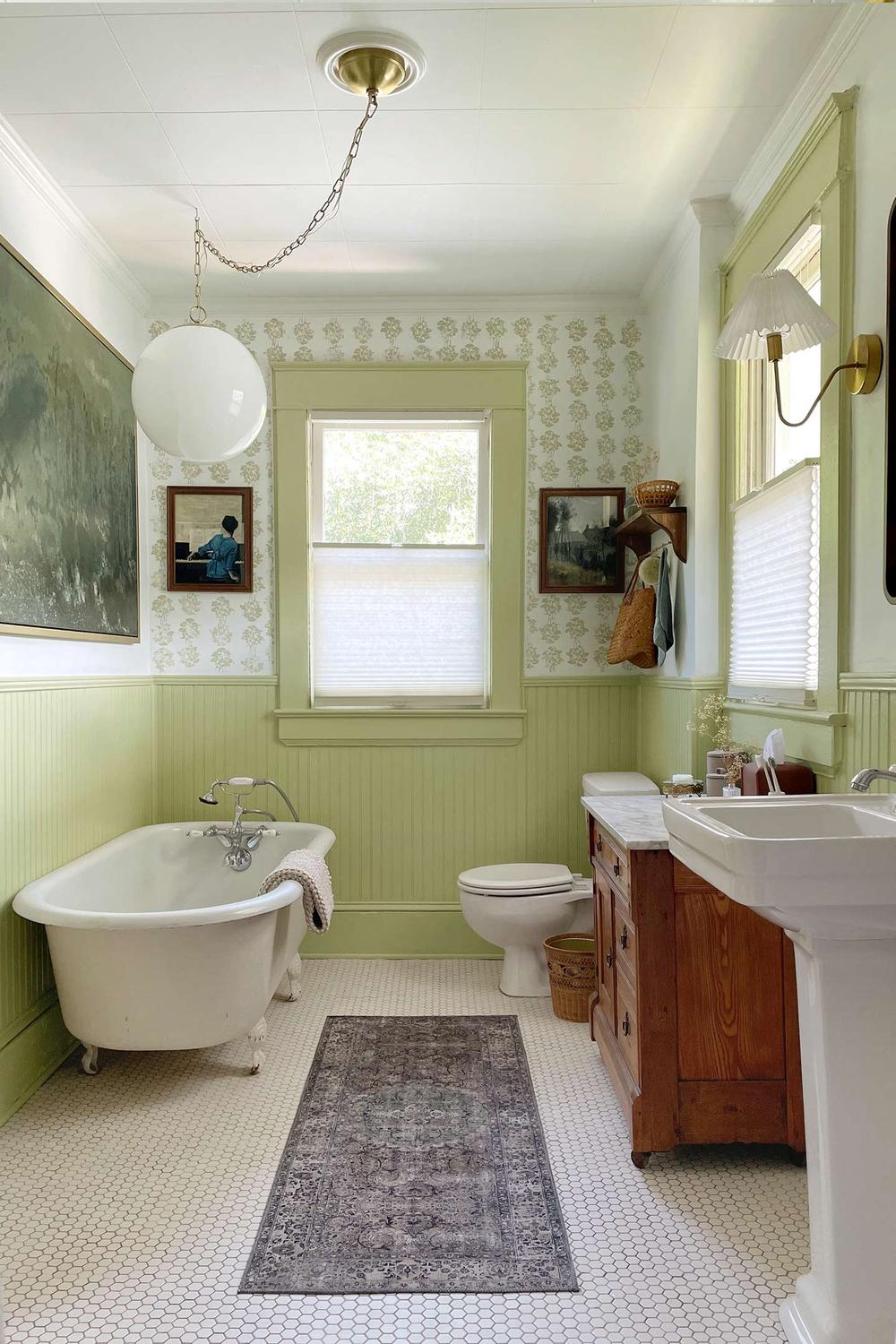 Baño vintage encantador con toques verdes y azulejos decorativos