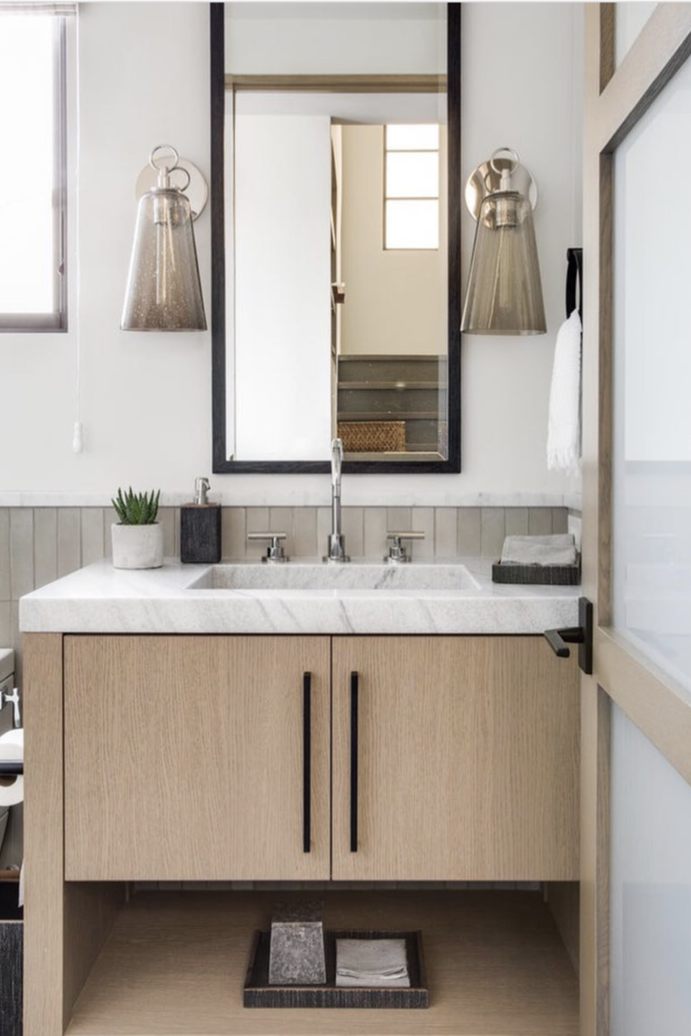 Moderno baño organizado con alfeizares de tonos suaves y lavabo contemporáneo