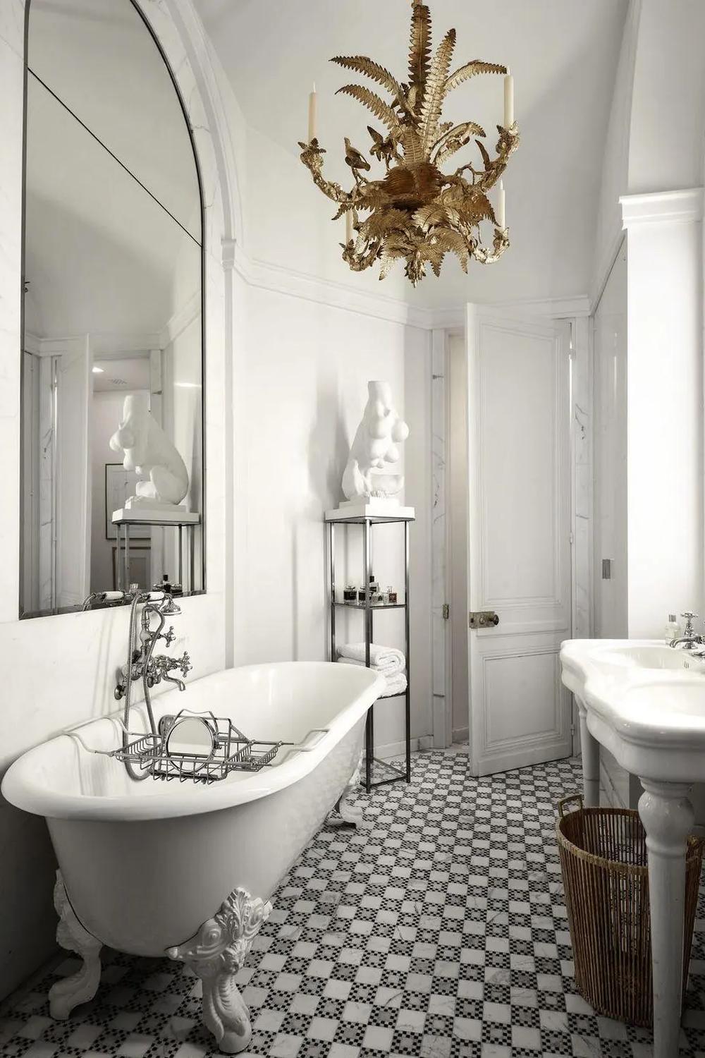 Vintage styled bathroom featuring an antique clawfoot tub, elegant chandelier, and contemporary accents for a timeless feel.
