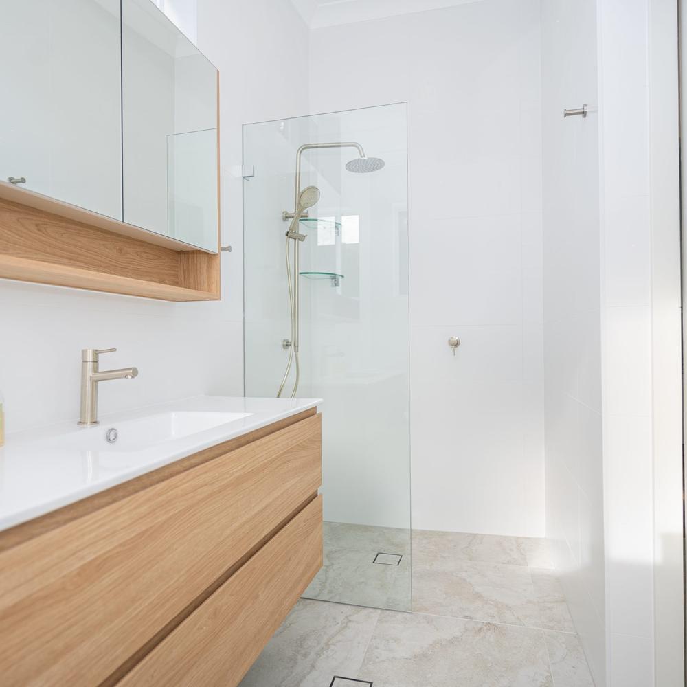 Minimalist bathroom featuring a sleek vanity, spacious functionality, and elegant simplicity throughout the design.