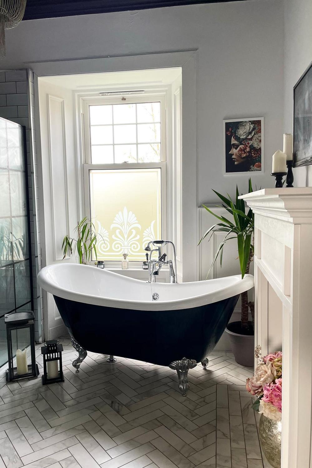 Luxurious bathroom featuring a black and white clawfoot tub against a beautifully patterned floor highlighting the bold accents.