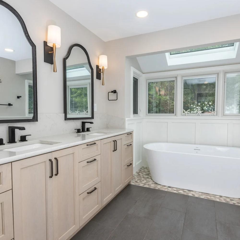Inviting bathroom design with natural light from large windows, textures, and a well-organized personal touch for comfort.