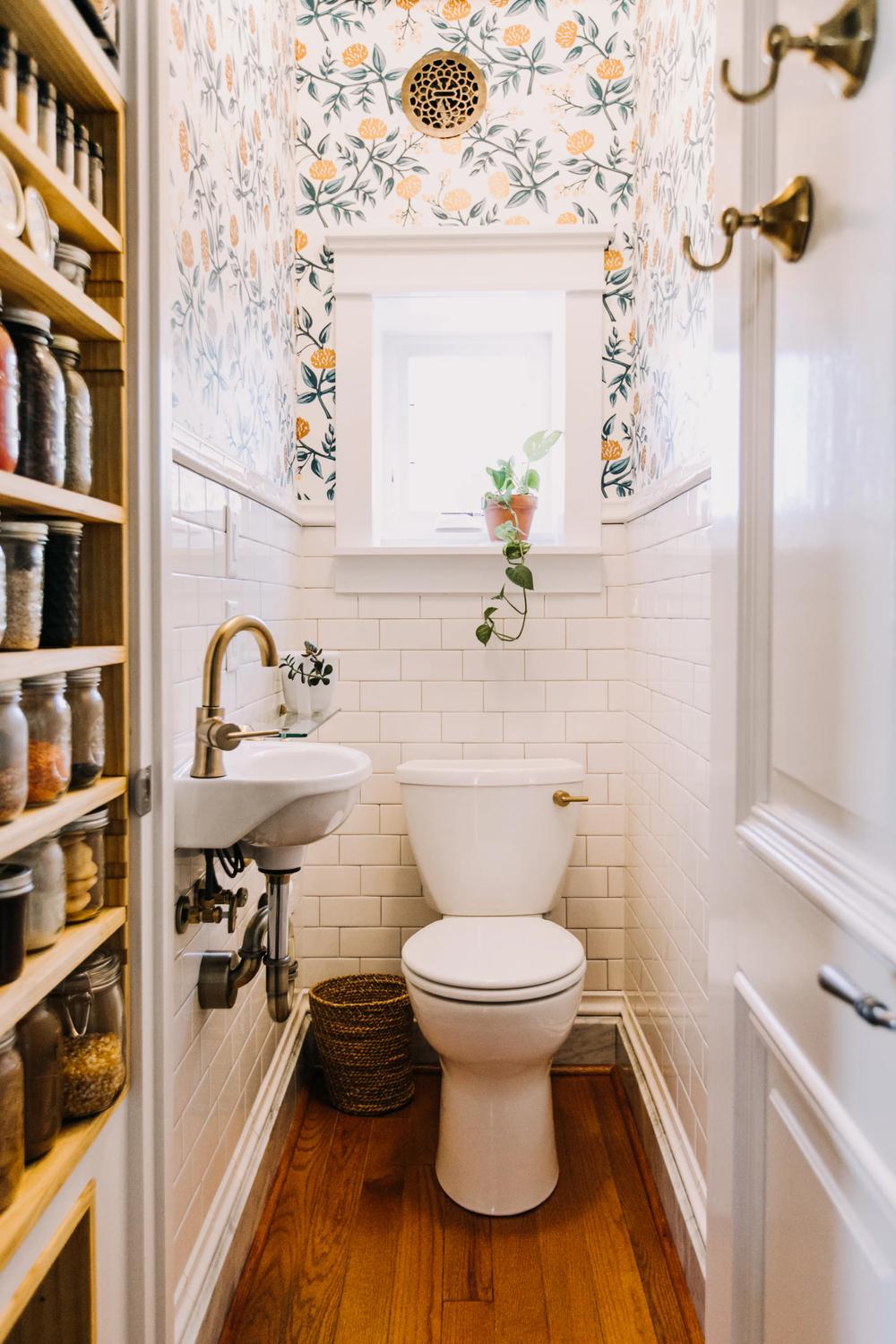 Adorable small bathroom decorated with floral wallpaper and modern fixtures, enhancing its charm and elegance.