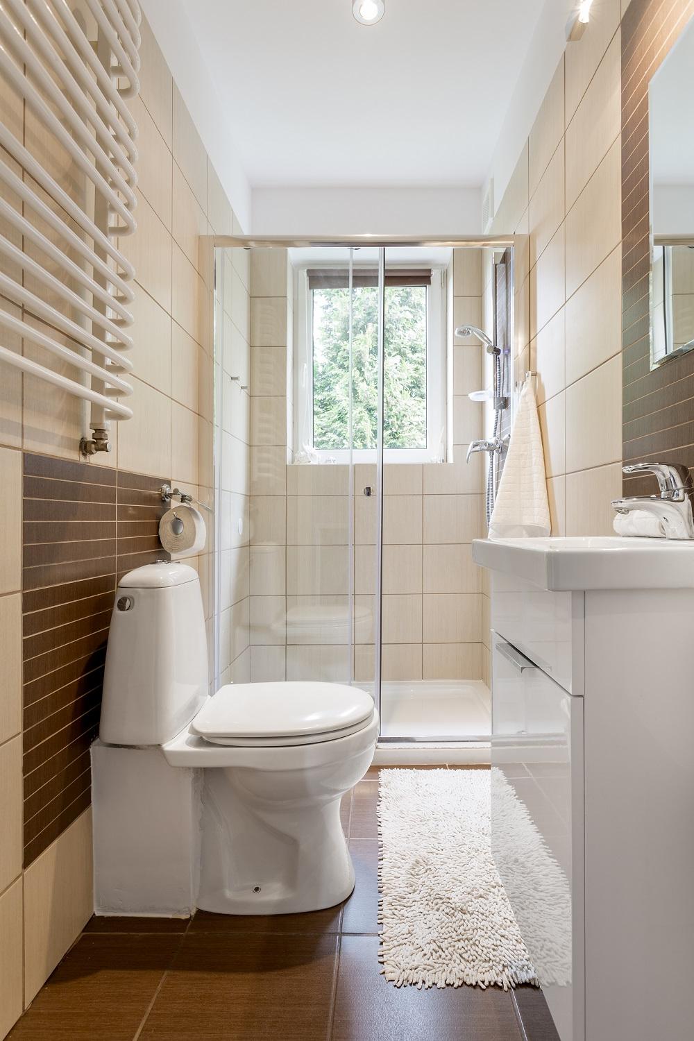 Baño pequeño con azulejos beige y diseño funcional