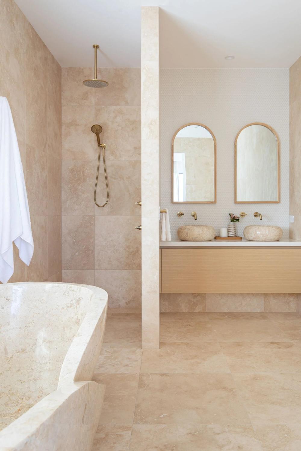 Baño con azulejos de travertino y toques naturales
