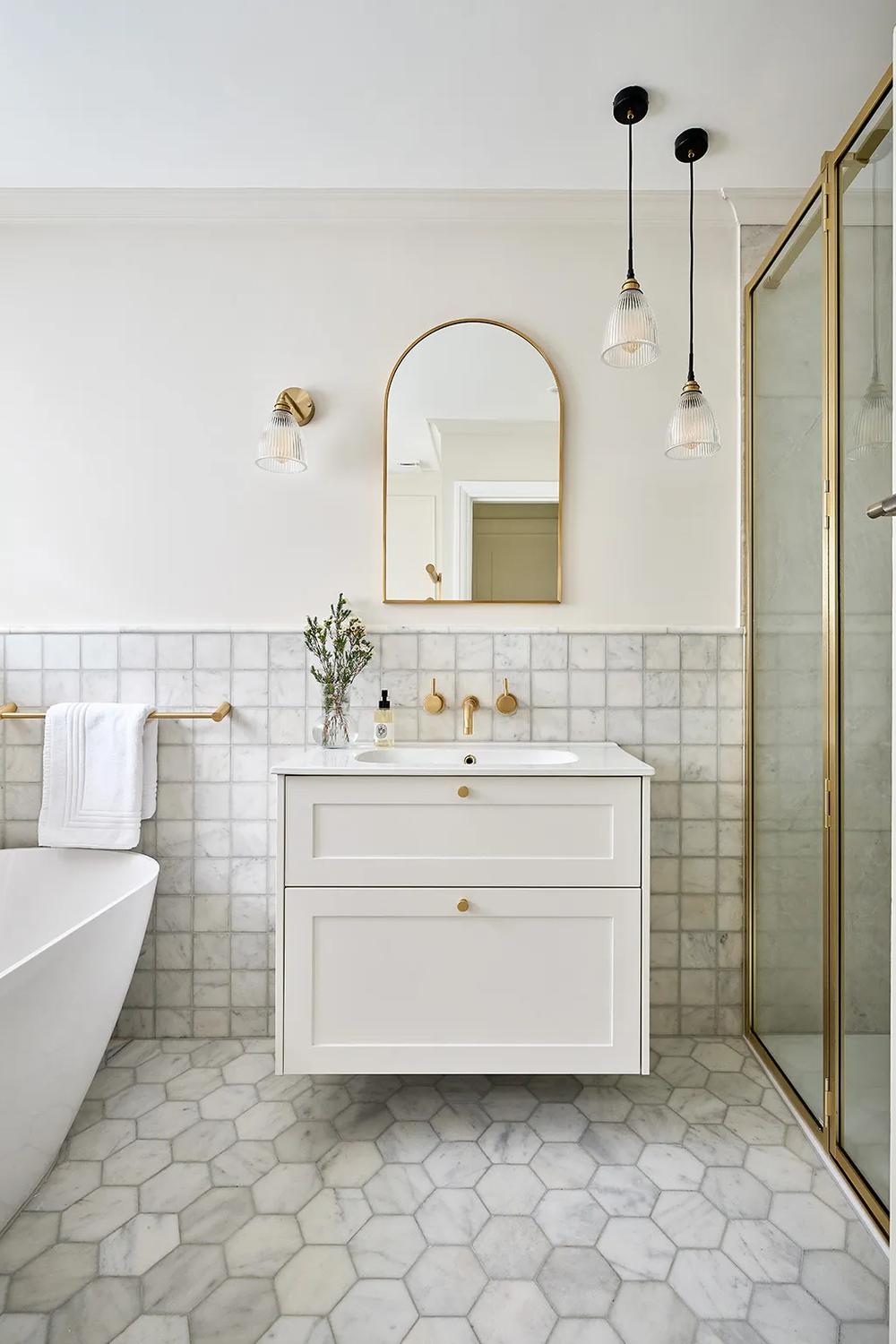 Baño modernista con azulejos de mármol y mueble blanco