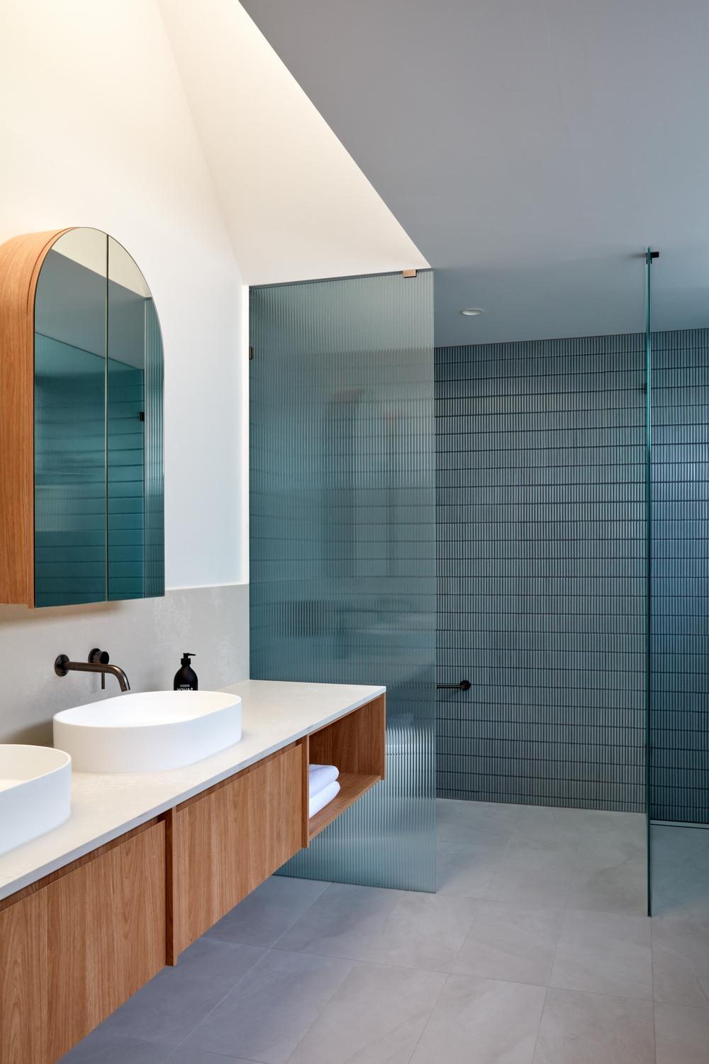 Baño moderno con azulejos turquesa y texturas suaves