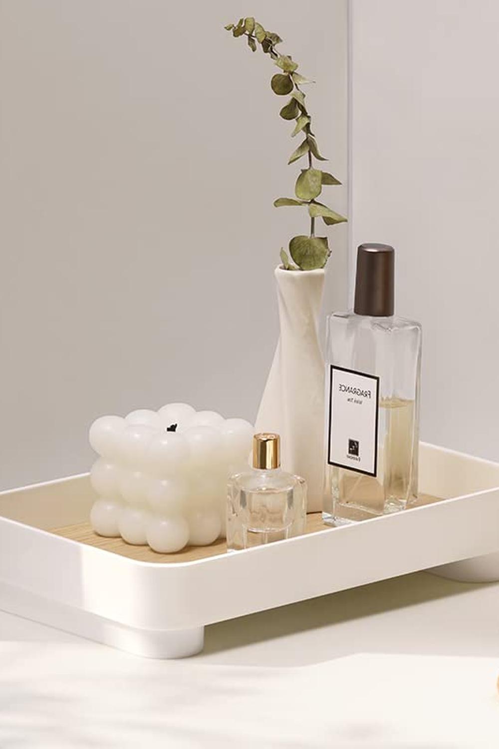 Sleek white vanity tray with rounded edges, holding bubble-shaped candle, perfume bottles, and eucalyptus vase.