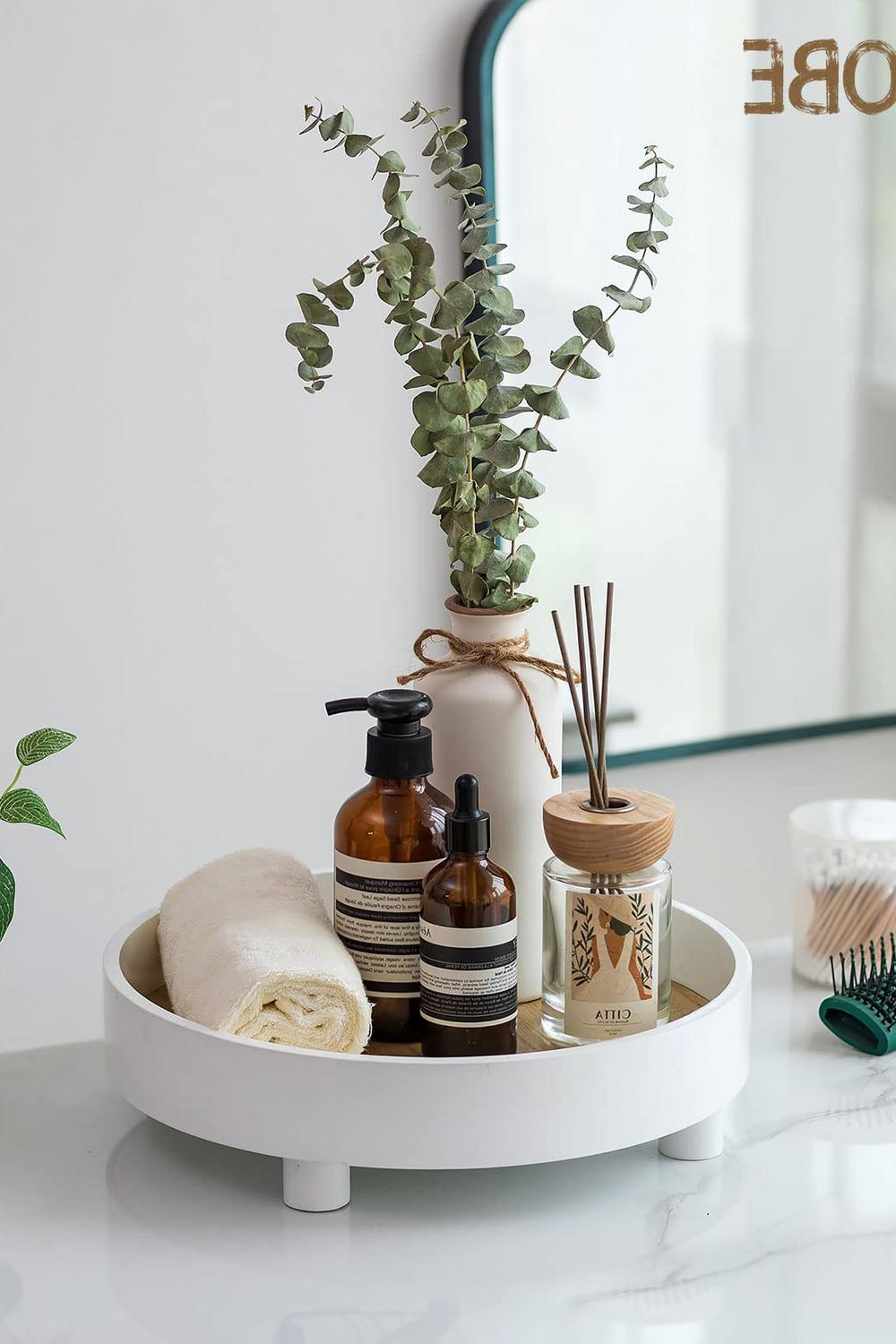 Stylish white vanity tray with a golden interior and elegant beauty products.