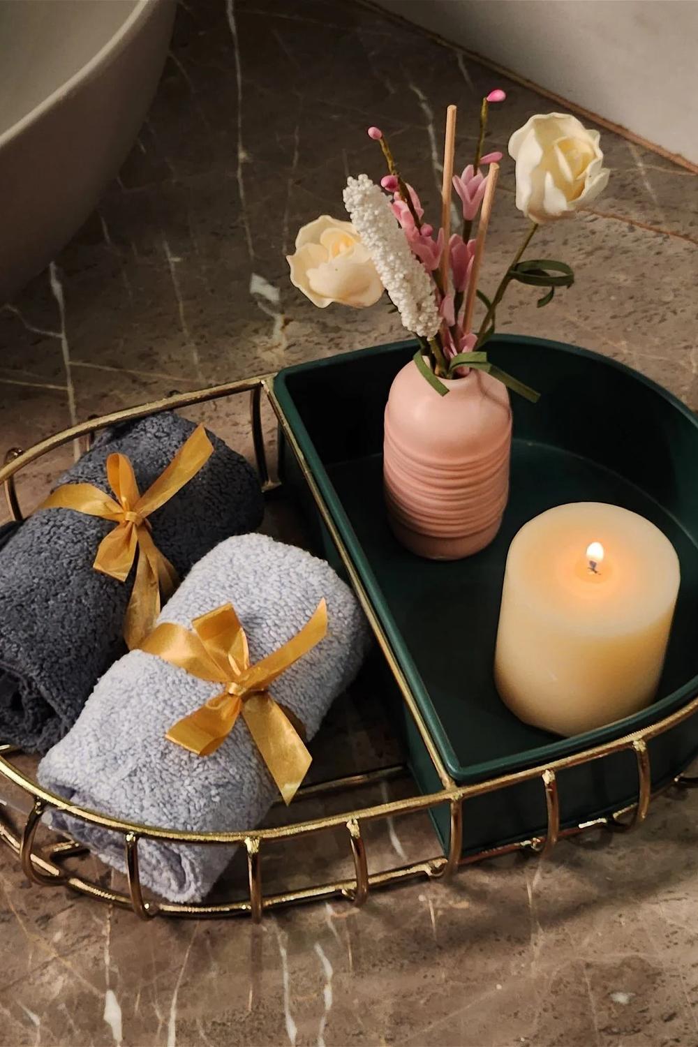 Elegant oval vanity tray with textiles and decorative items.