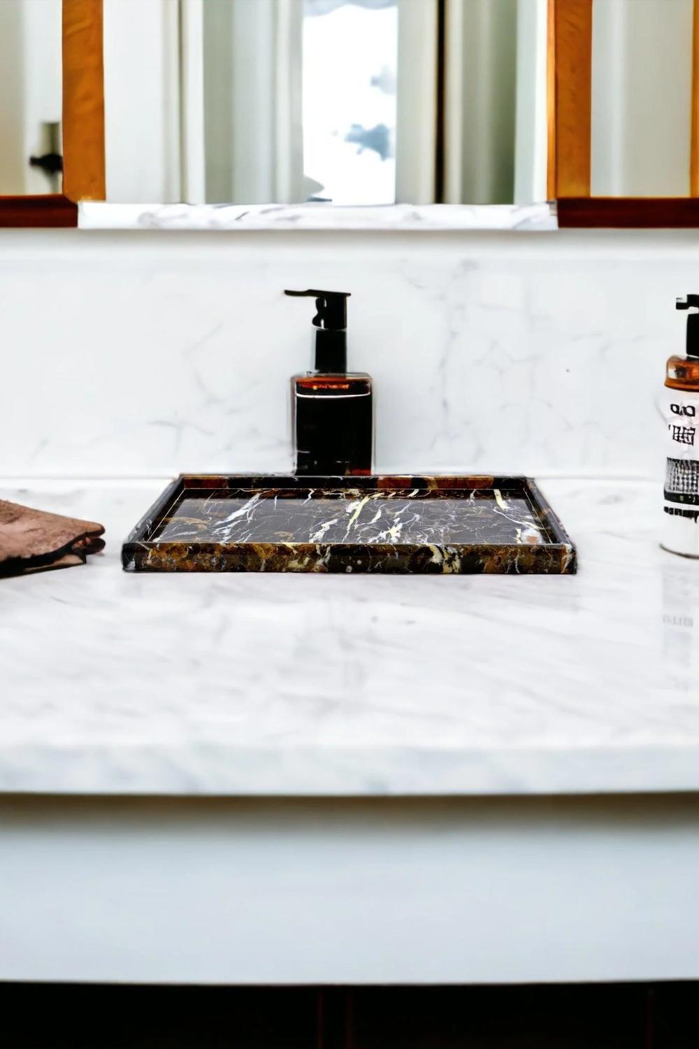 Dark luxurious vanity tray set against a light marble countertop.
