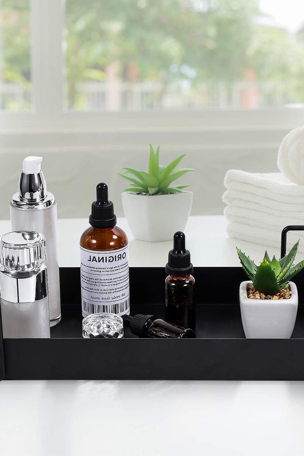 Modern matte black vanity tray with delicate decor and organized products.