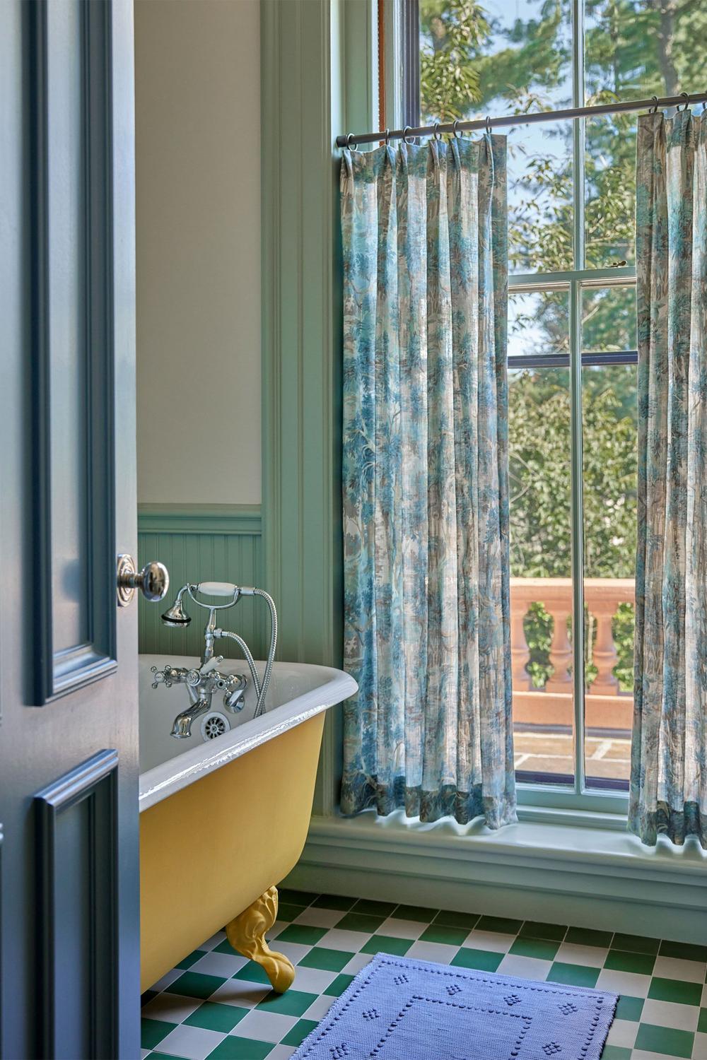 Baño divertido y ligero con bañera amarilla y azulejos en check