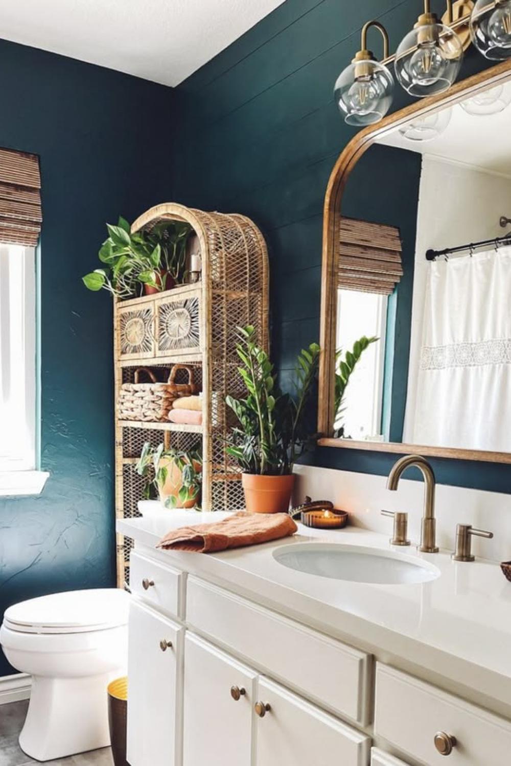 A stylish bathroom with teal walls, white cabinetry, and natural wood accents