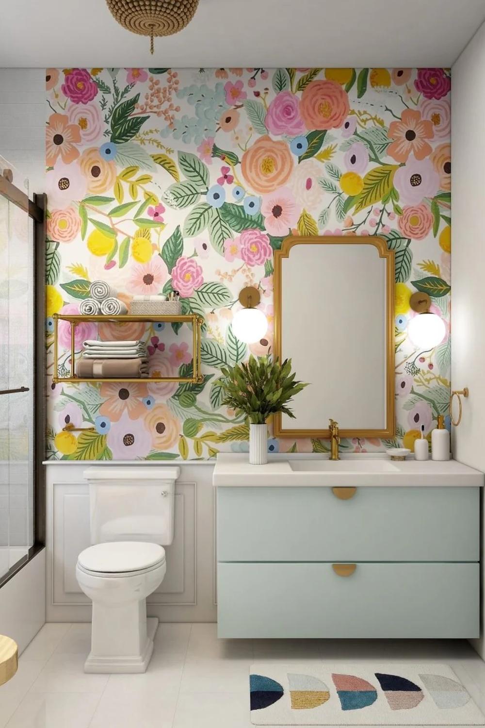 A modern bathroom with colorful floral wallpaper and pastel blue vanity