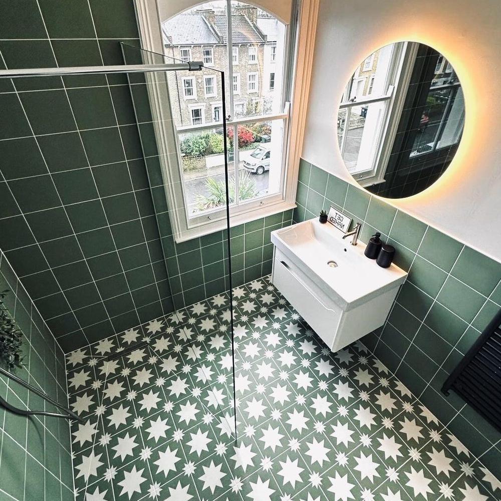 A stylish bathroom featuring verdant green tiles and white accents