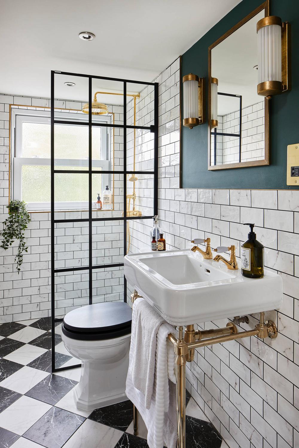 A Victorian-style bathroom showcasing white subway tiles and contrasting deep green accents.