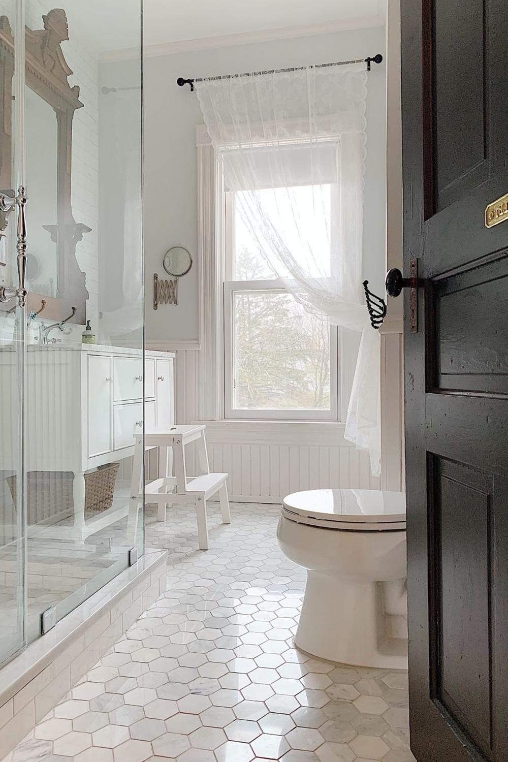 A beautifully designed Victorian bathroom showcasing hexagonal marble tiles and a modern toilet.