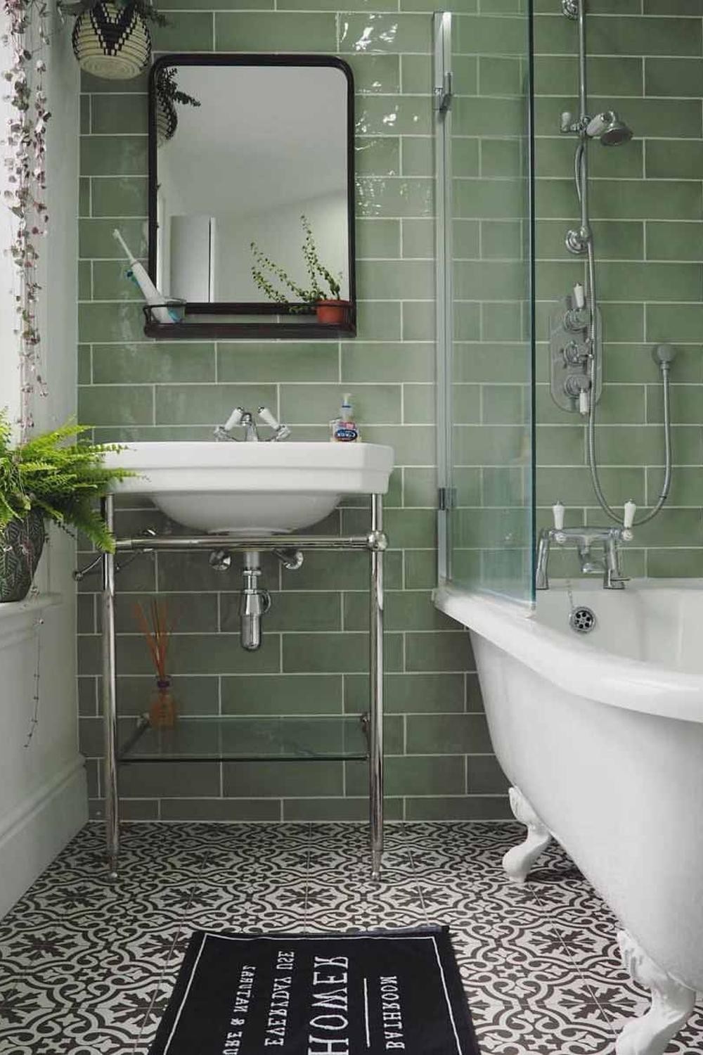 A vintage-inspired Victorian bathroom with glazed green tiles and a minimalist style.