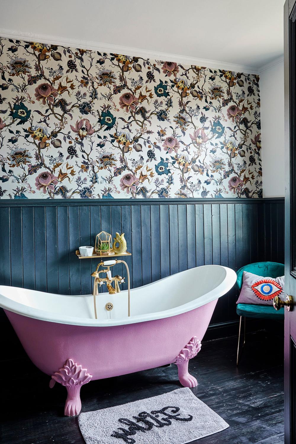 A Victorian-style bathroom featuring floral wallpaper and gold-toned fixtures.