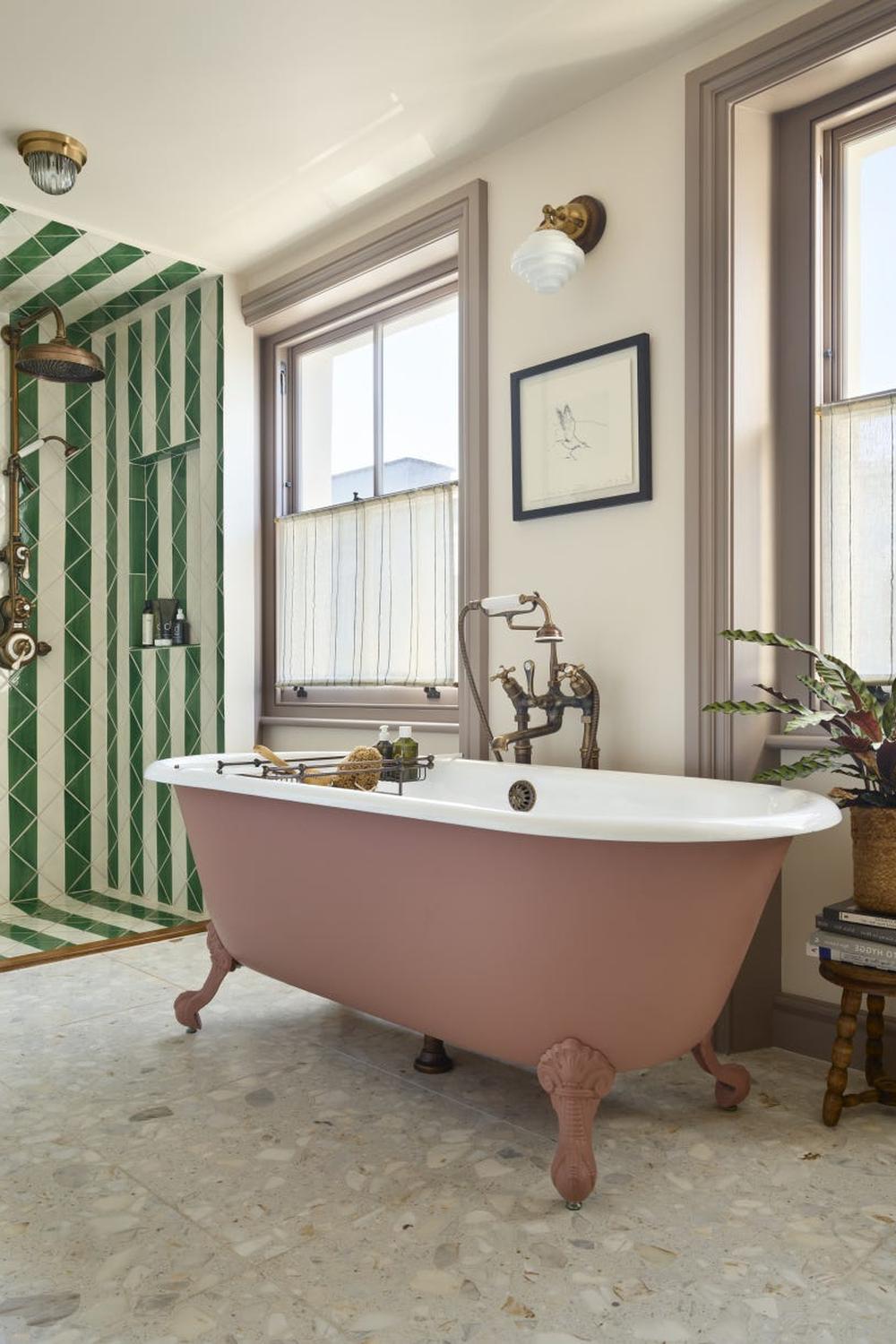 A beautifully designed Victorian bathroom featuring a pink bathtub and modern shower area.