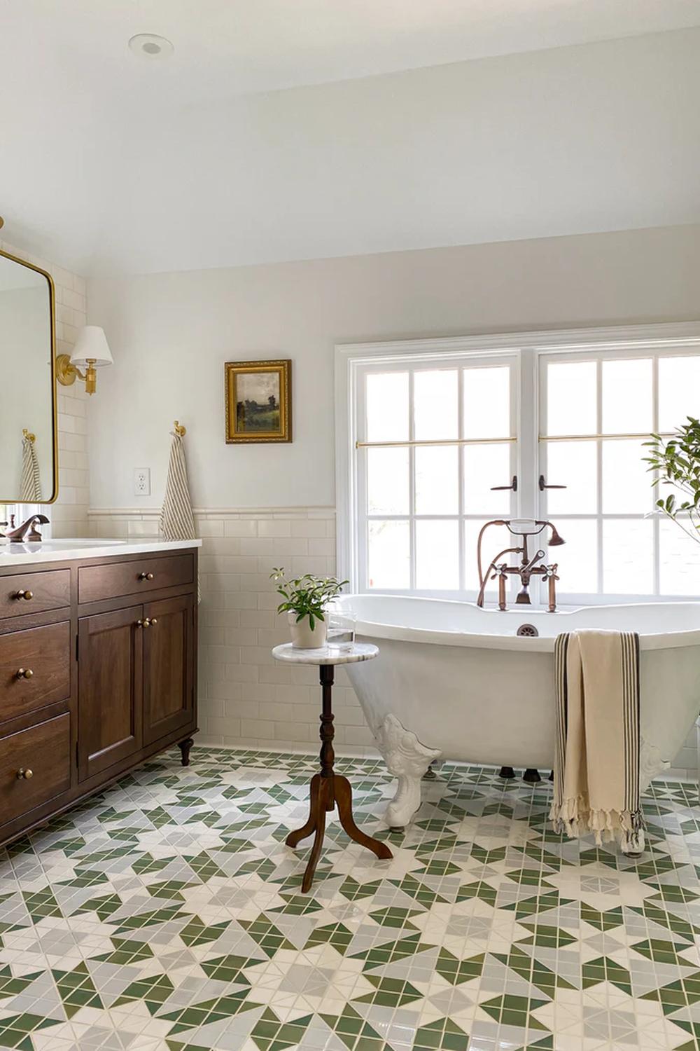 Vintage bathroom featuring intricate green geometric floor tiles and a classic freestanding bathtub.