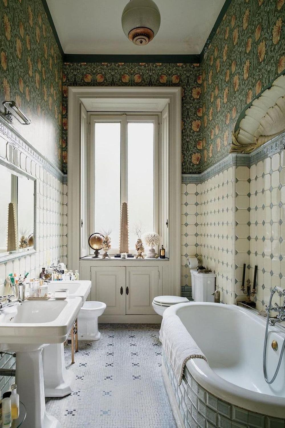 Elegant vintage bathroom with green floral wallpaper and off-white hexagonal tiles.