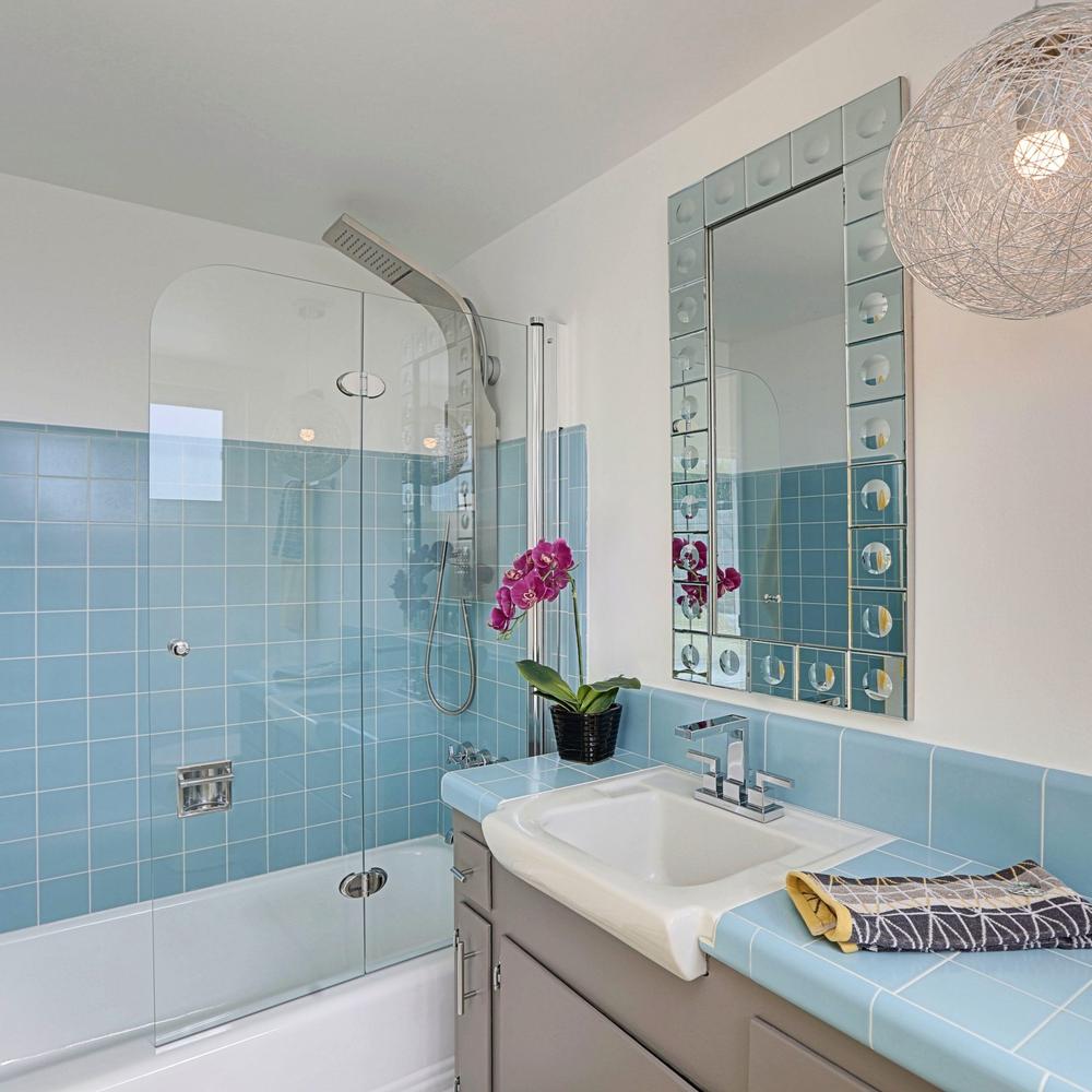 Vintage-inspired bathroom with light blue tiles and modern shower enclosure.