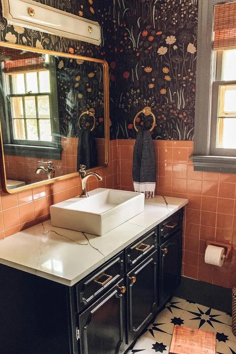 Vintage-inspired bathroom featuring pink tiles and whimsical floral wallpaper showing personality.