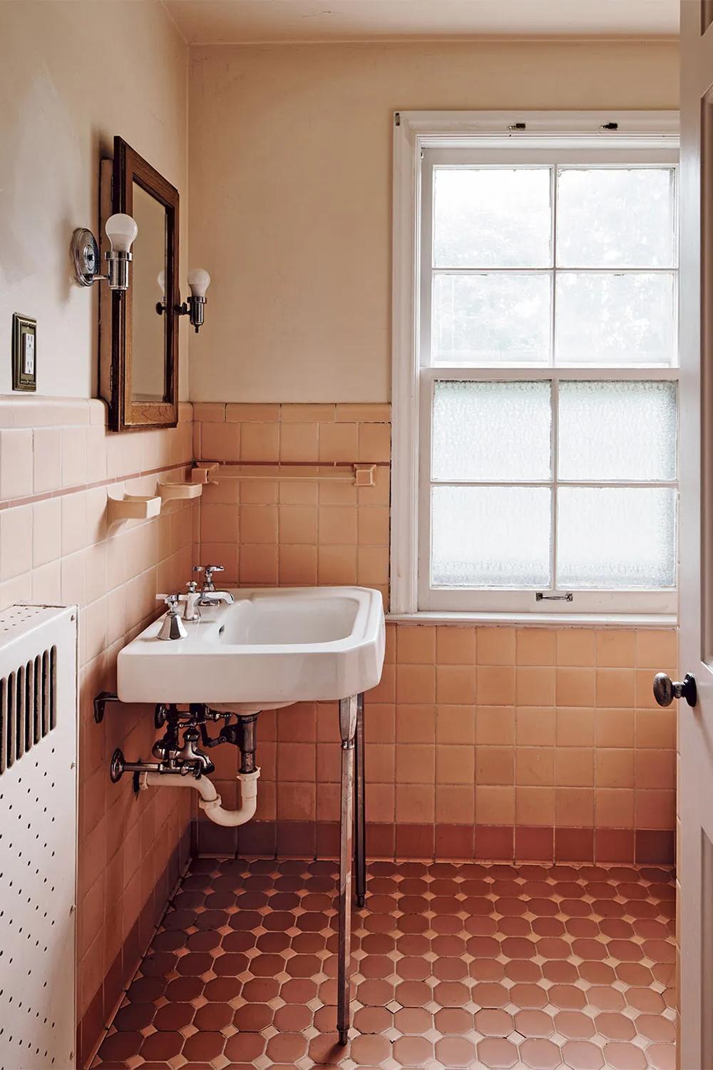 Retro chic bathroom with pastel pink tones and chrome fixtures.