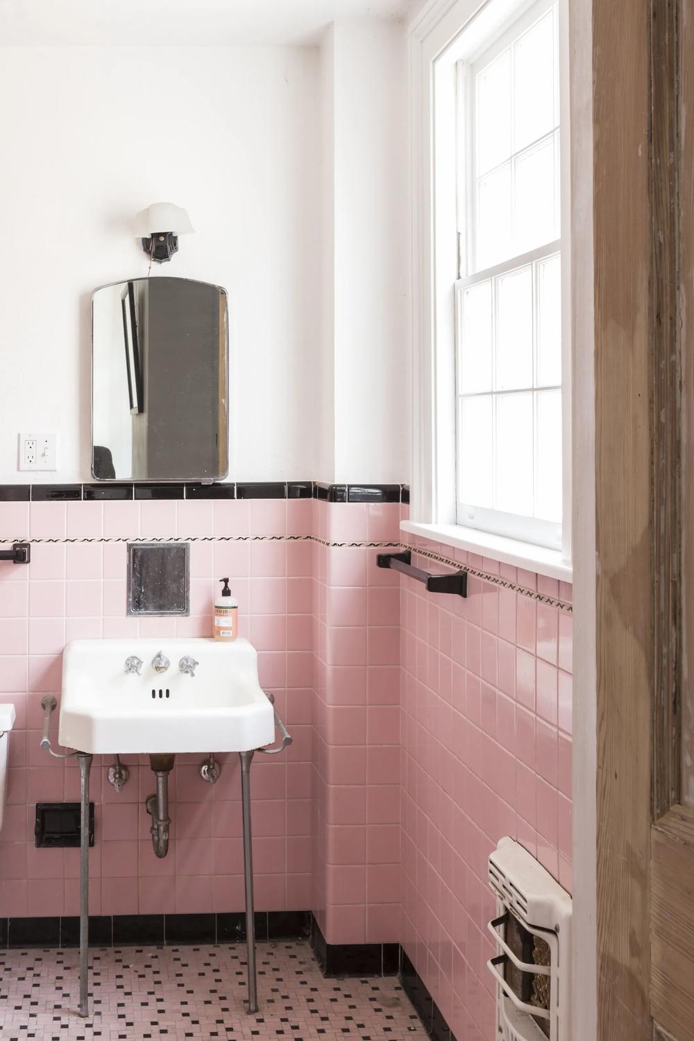 Vintage elegantly styled bathroom featuring pink tiles and classic fixtures.