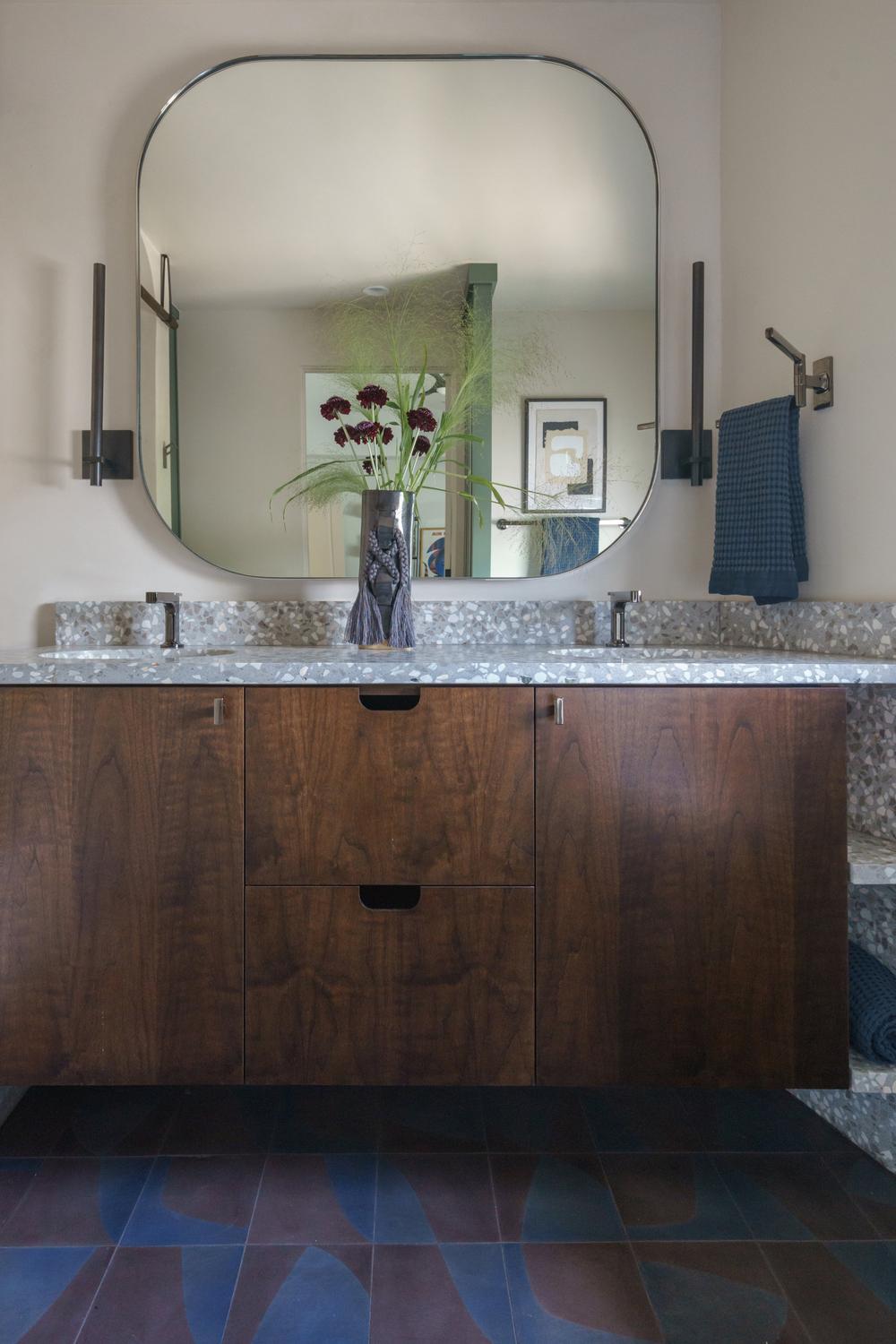 Baño wabi-sabi con mueble de madera rústica y decoración natural.