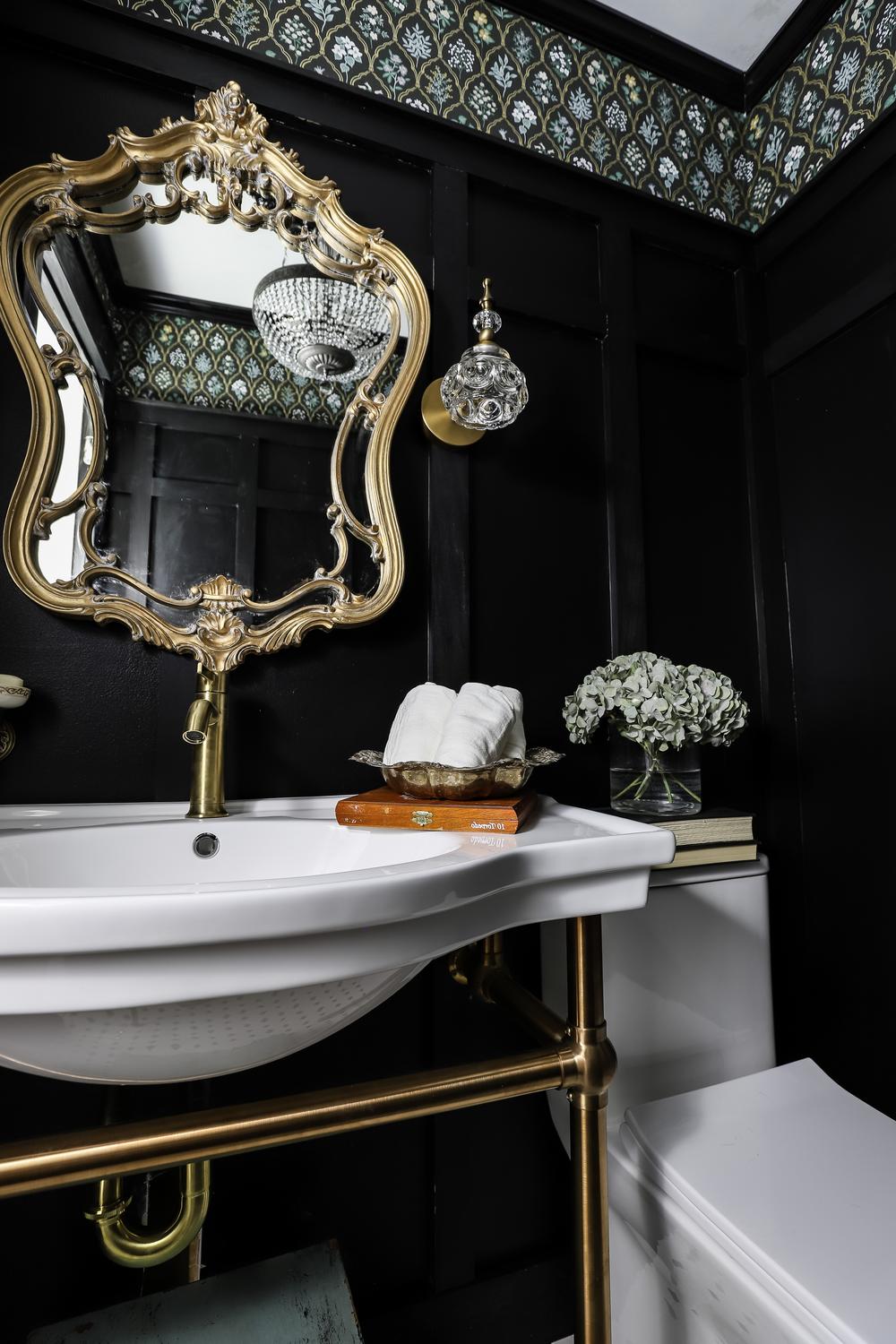 Baño elegante con techo negro y detalles dorados