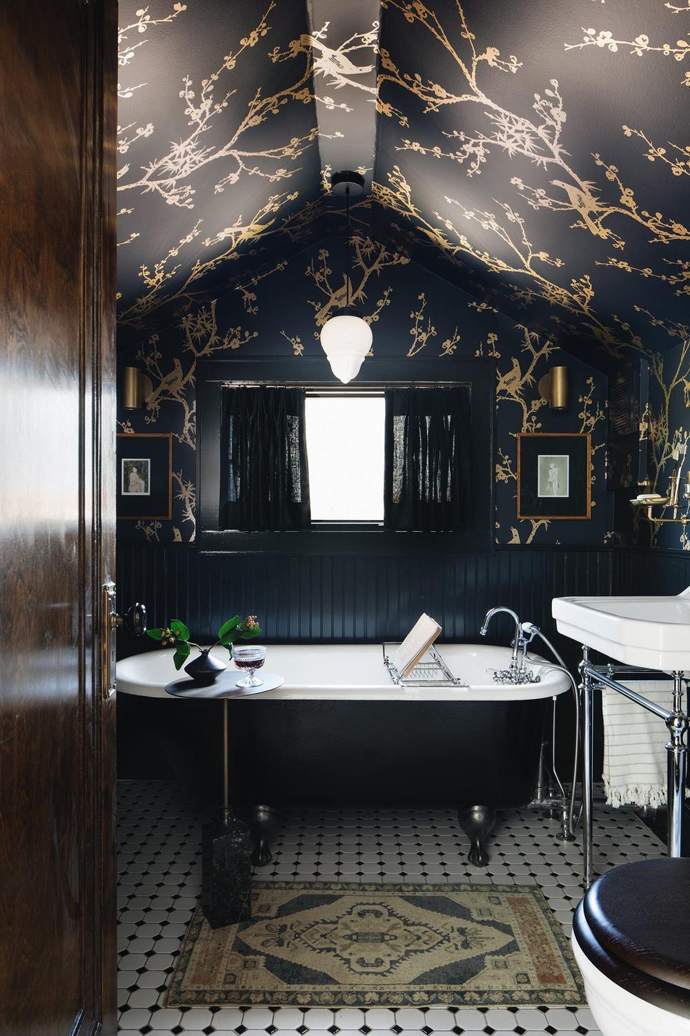 Baño elegante con techo florales en contraste negro y dorado