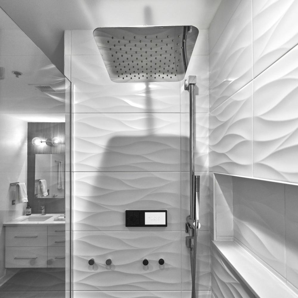 Ducha moderna con azulejos ondulados y detalles minimalistas.