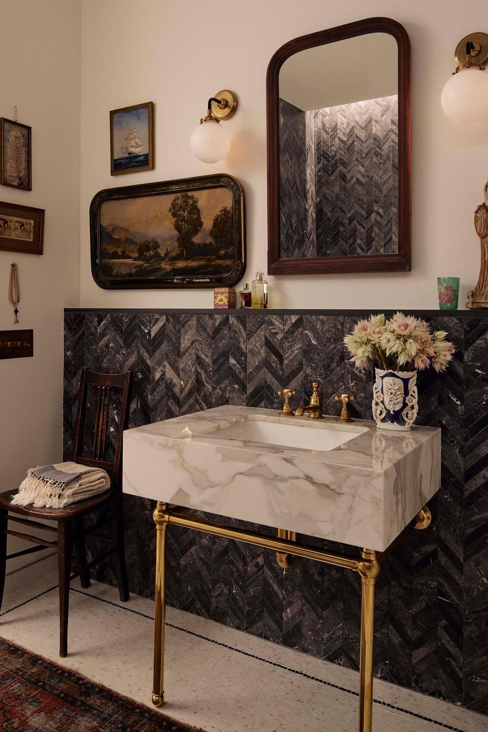 Baño sofisticado con azulejos chevron y elementos decorativos elegantes.
