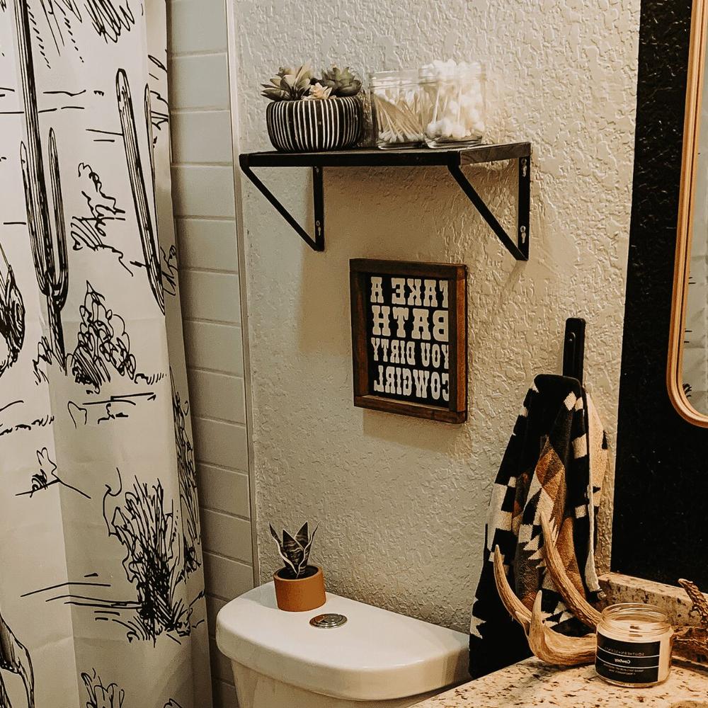 Baño western con decoración humorística y cactus