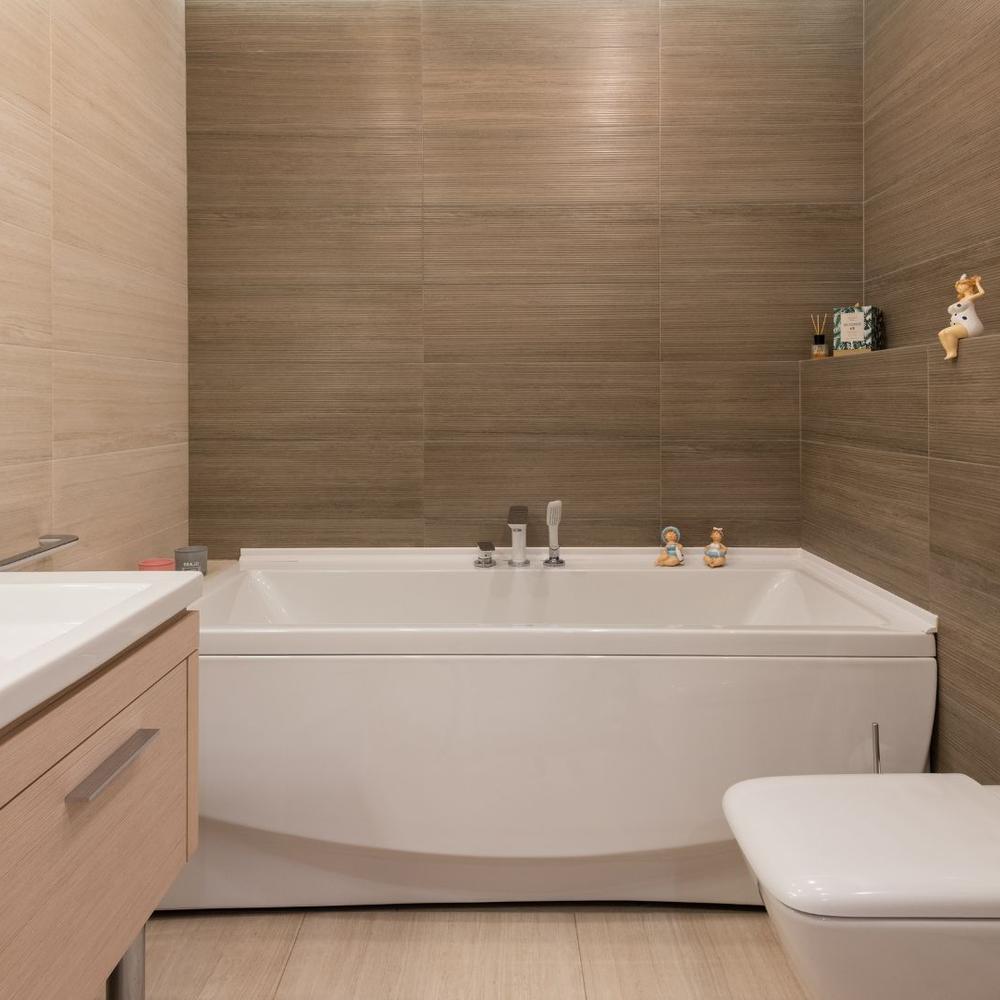 A relaxing bathroom featuring a corner bathtub and soft lighting.
