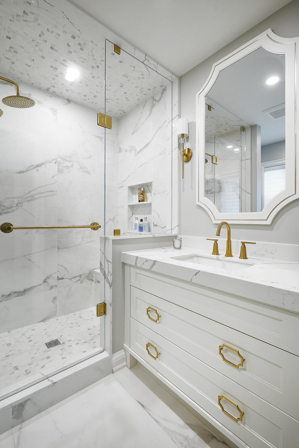 Elegant white bathroom featuring luxurious gold fixtures creating a sophisticated ambiance.