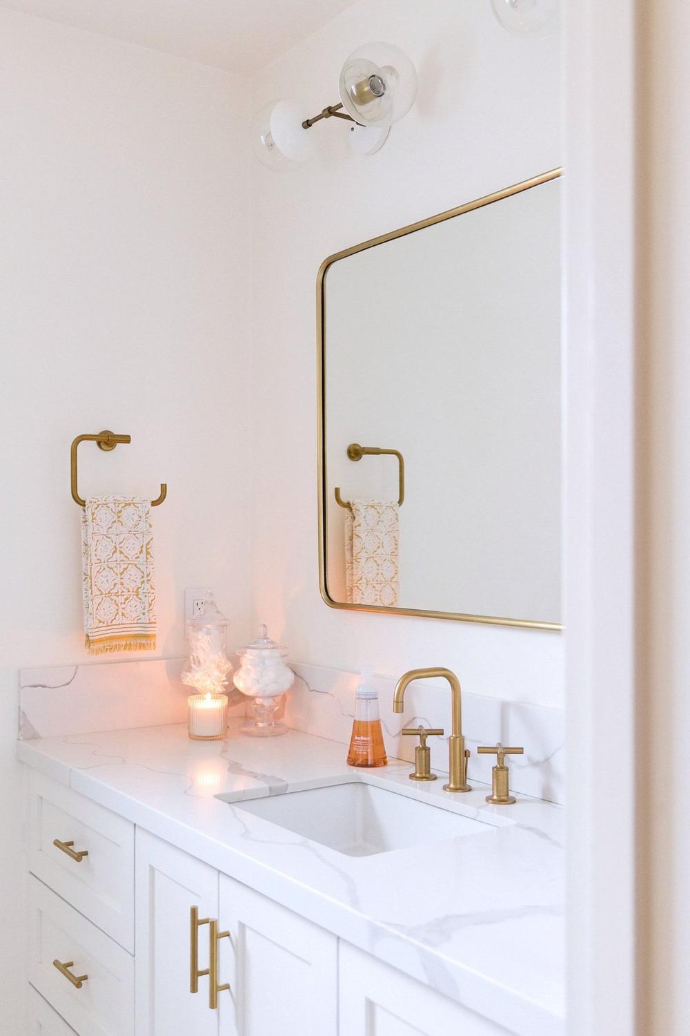 Chic modern bathroom with a white backdrop and graceful gold accents.