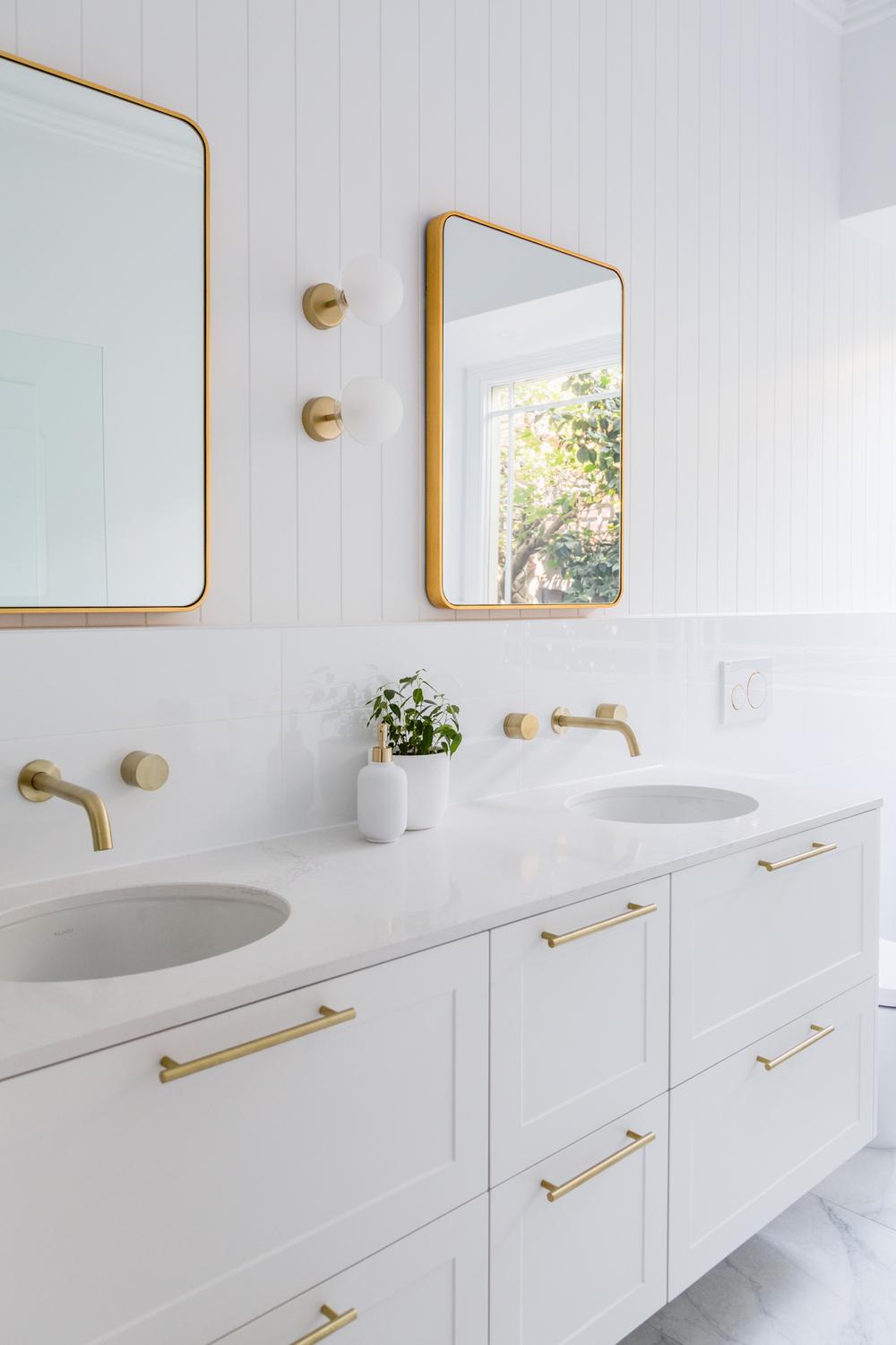 Minimalist aesthetic bathroom featuring clean lines and gold fixtures.