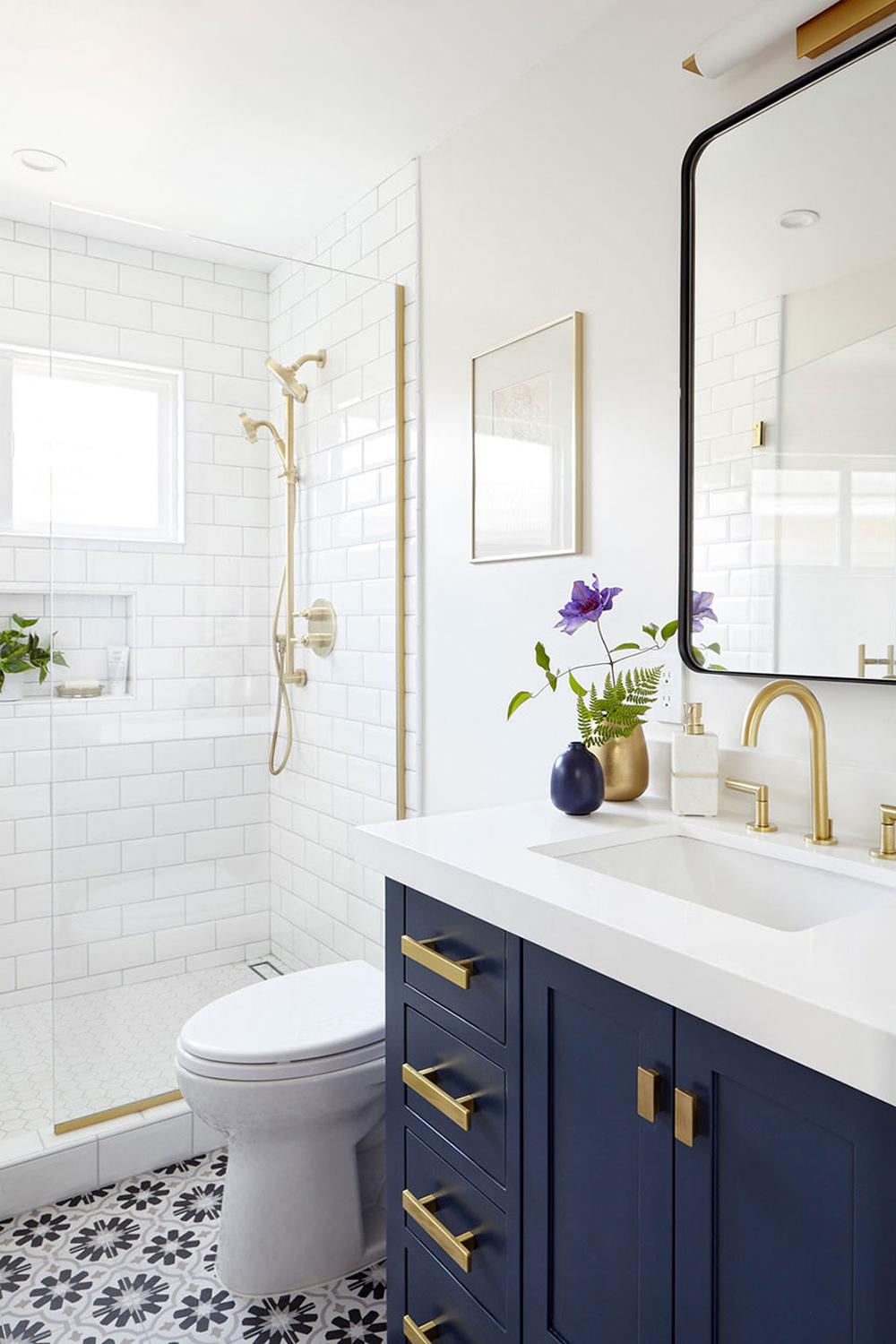 Modern bathroom featuring navy elements and gold fixtures.